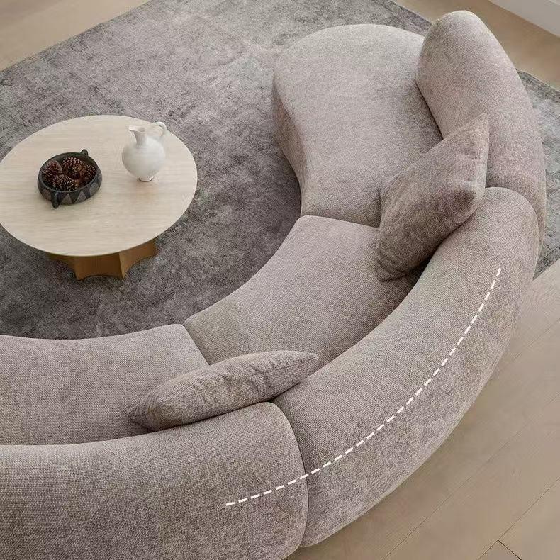 Rounded Beige Chaise Sofa with Soft Barrel Arms and Plush Pillows