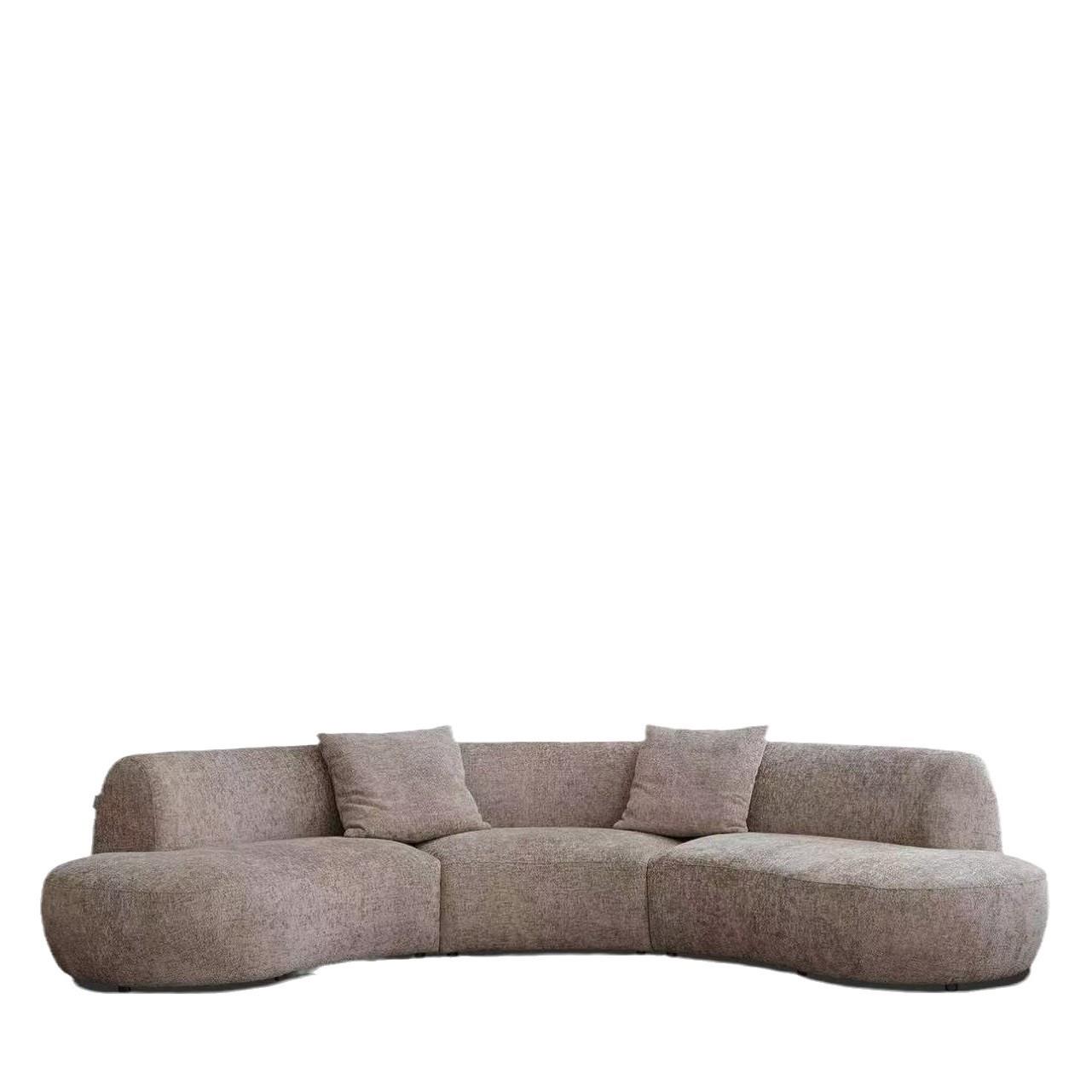 Rounded Beige Chaise Sofa with Soft Barrel Arms and Plush Pillows