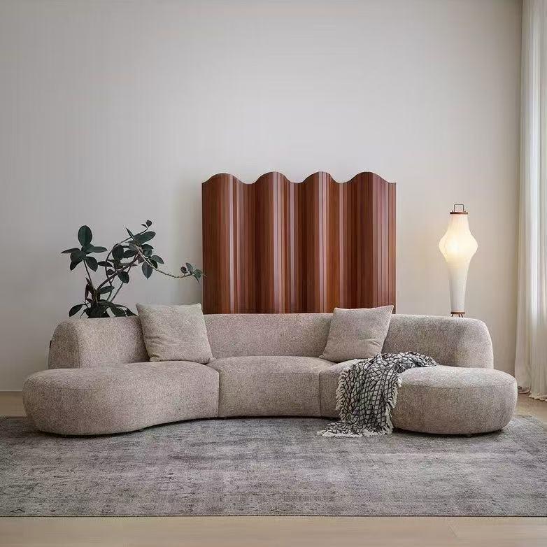 Rounded Beige Chaise Sofa with Soft Barrel Arms and Plush Pillows